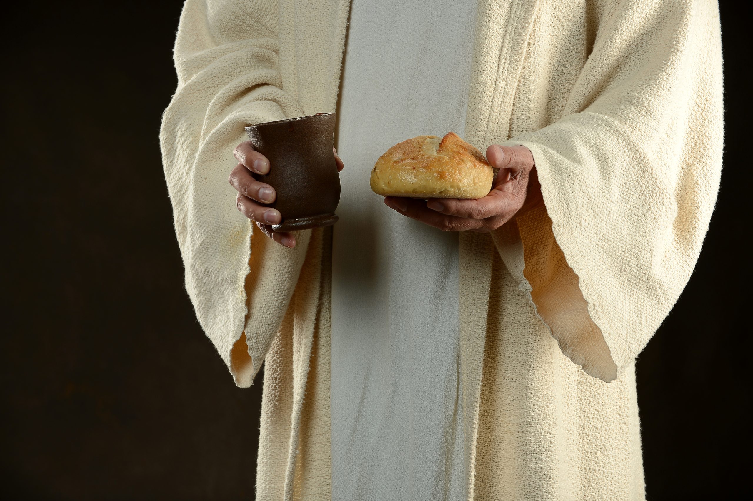 Jesus holding bread and a cup of wine as a methaphore